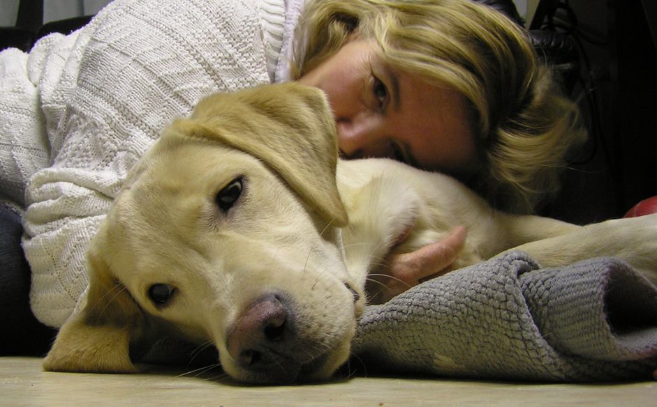 A woman cuddling with a dog