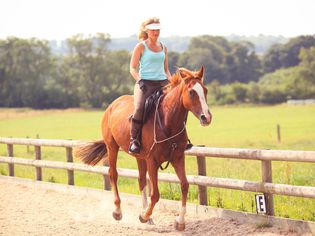 Woman riding a horse on a track