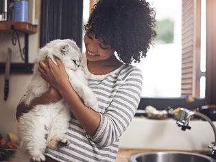 女子在厨房抱着猫